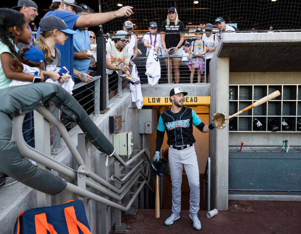 Colorado Rockies third baseman Kris Bryant, middle, interacts with fans during a rehab assignme ...