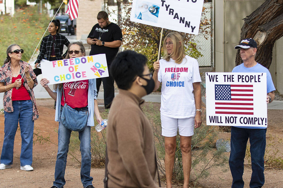 A UNLV student walks past Janice Brosmr, second left, Julie Williams and her husband, Terry, al ...