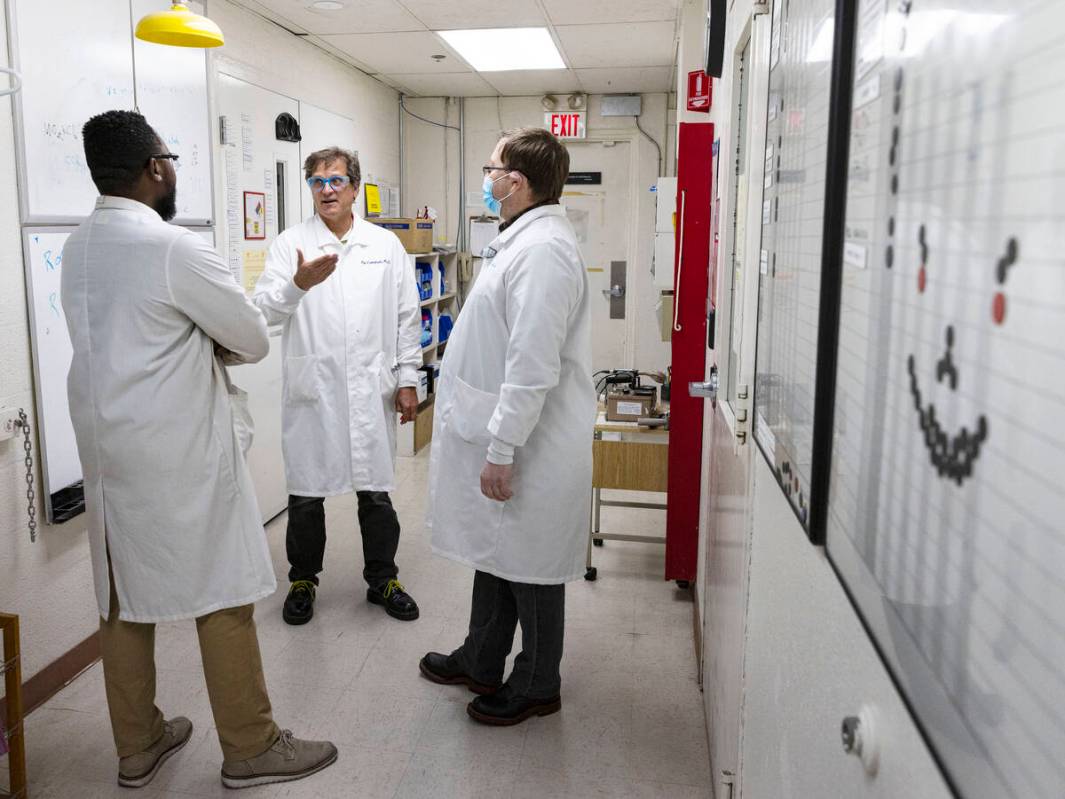 UNLV radiochemistry professor Ken Czerwinski, center, discuss about uranium chloride chemistry ...