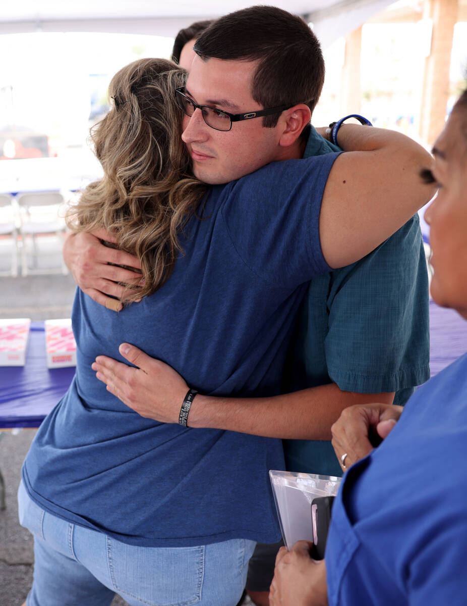 Sean Terry, son of late Las Vegas police Detective Justin Terry hugs Christa Swanger, wife of l ...
