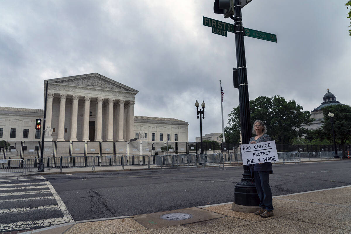 An abortion-rights activist stands outside the U.S. Supreme Court, Thursday, June 23, 2022, in ...