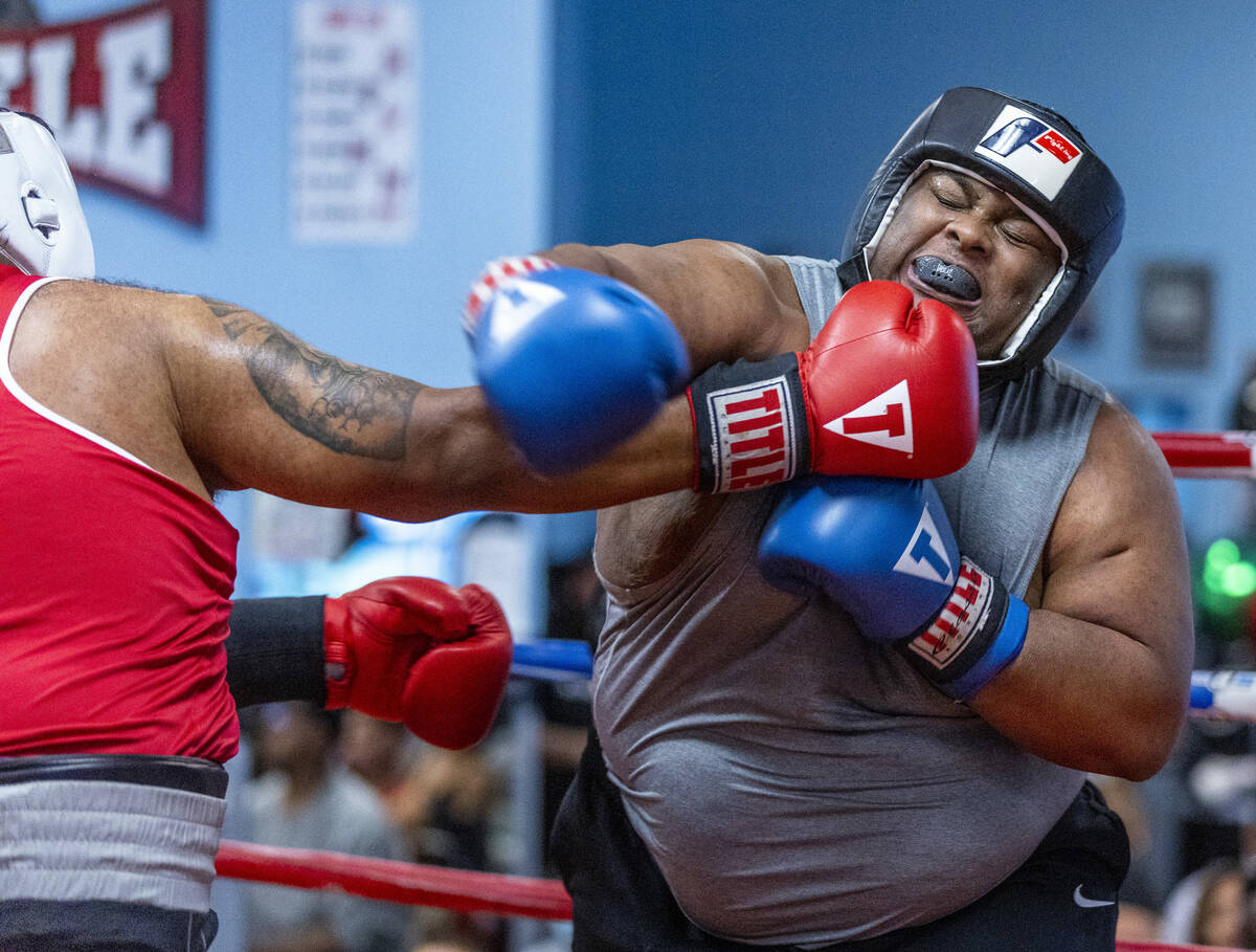 Angel Lopez, left, connects a punch to the chin of Chris Matthews in their 203+ pound match dur ...