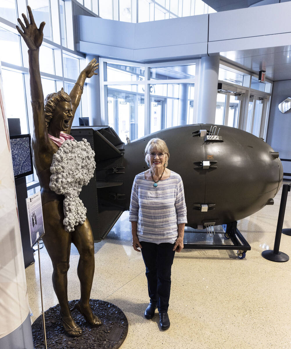 Jeanne Sharp Howerton poses for a photo between the sculpture of "Miss Atom Bomb," le ...