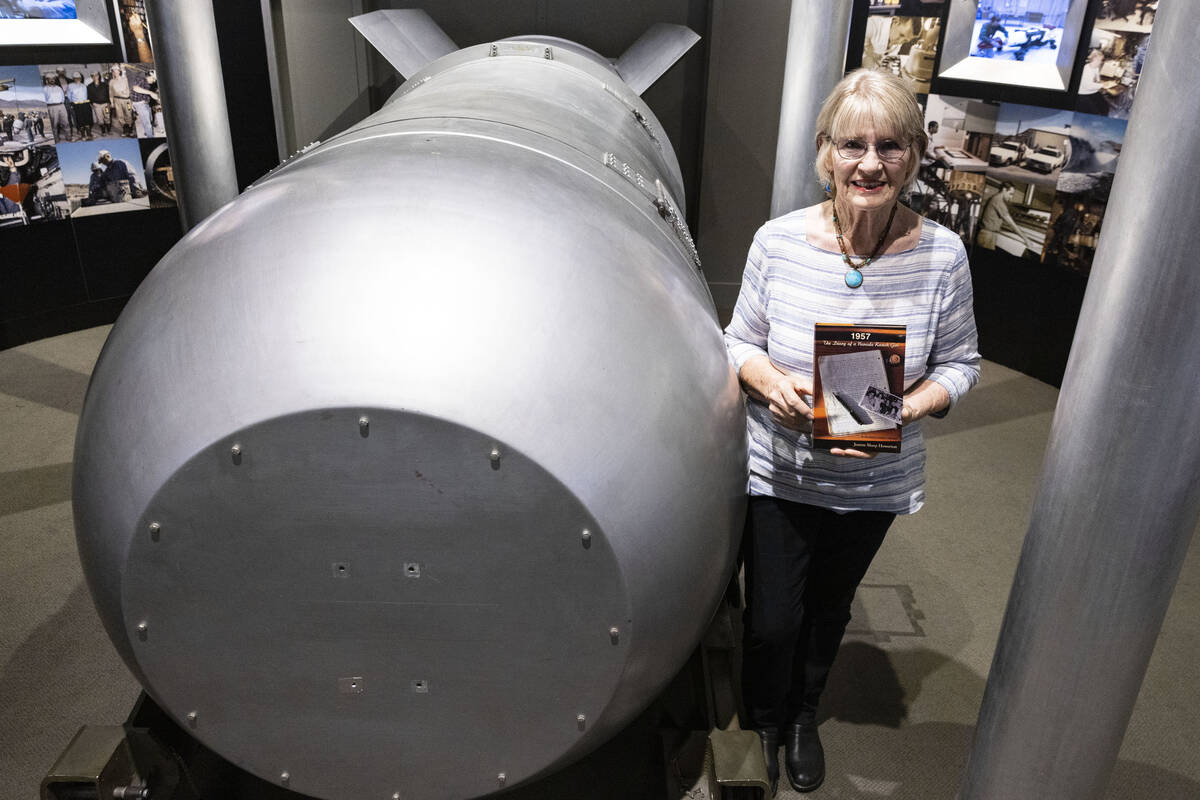 Jeanne Sharp Howerton holds her published book as she poses for a photo next to the casing of B ...