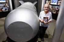 Jeanne Sharp Howerton holds her published book as she poses for a photo next to the casing of B ...