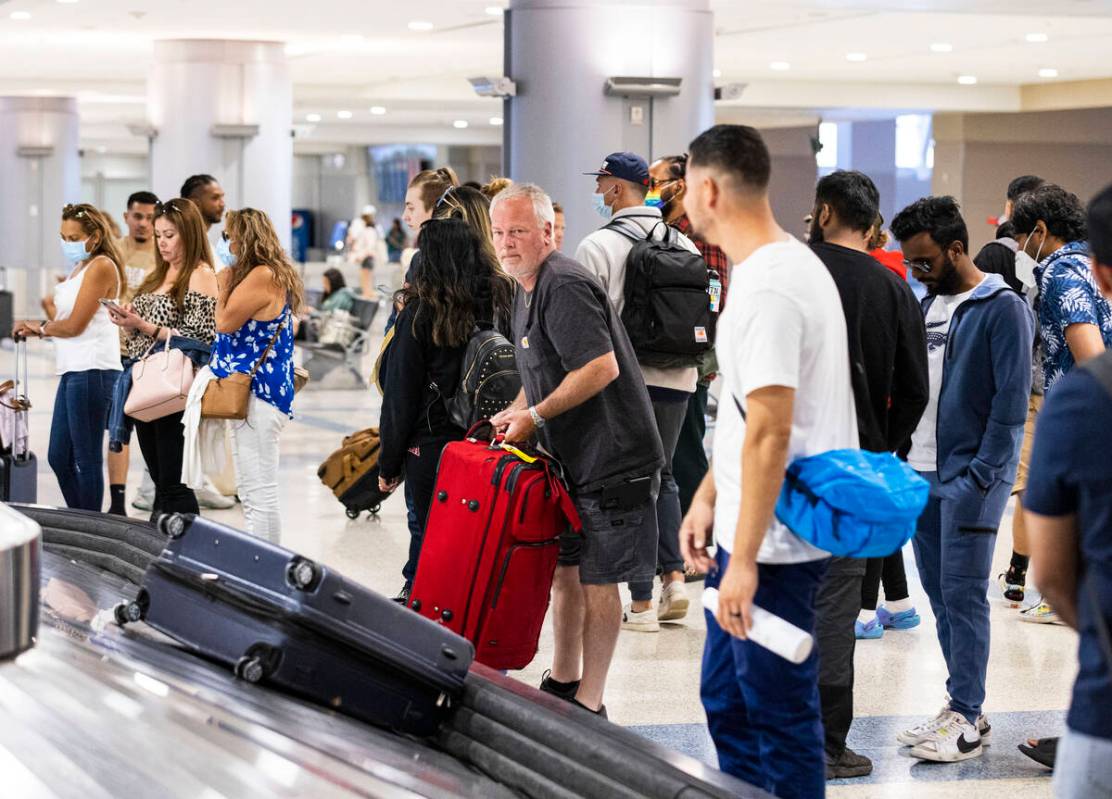 Arriving passengers wait for their luggage on the second floor of Terminal 3 baggage claim area ...