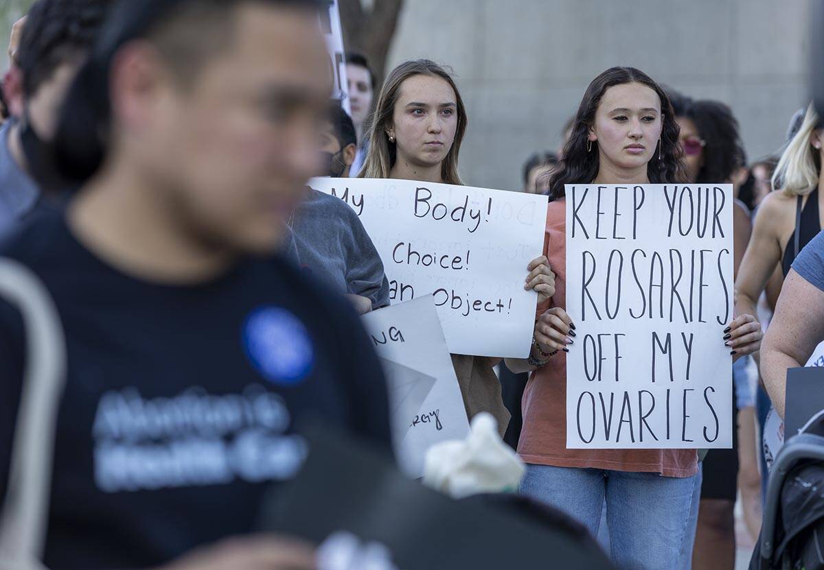 Protesters hold signs and gather to speak in response to Roe v. Wade being overturned today at ...