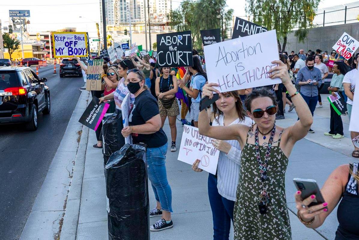 Protesters hold signs in response to Roe v. Wade being overturned today at the Lloyd D. George ...