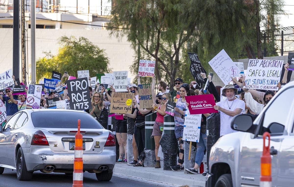 Protesters hold signs in response to Roe v. Wade being overturned today at the Lloyd D. George ...