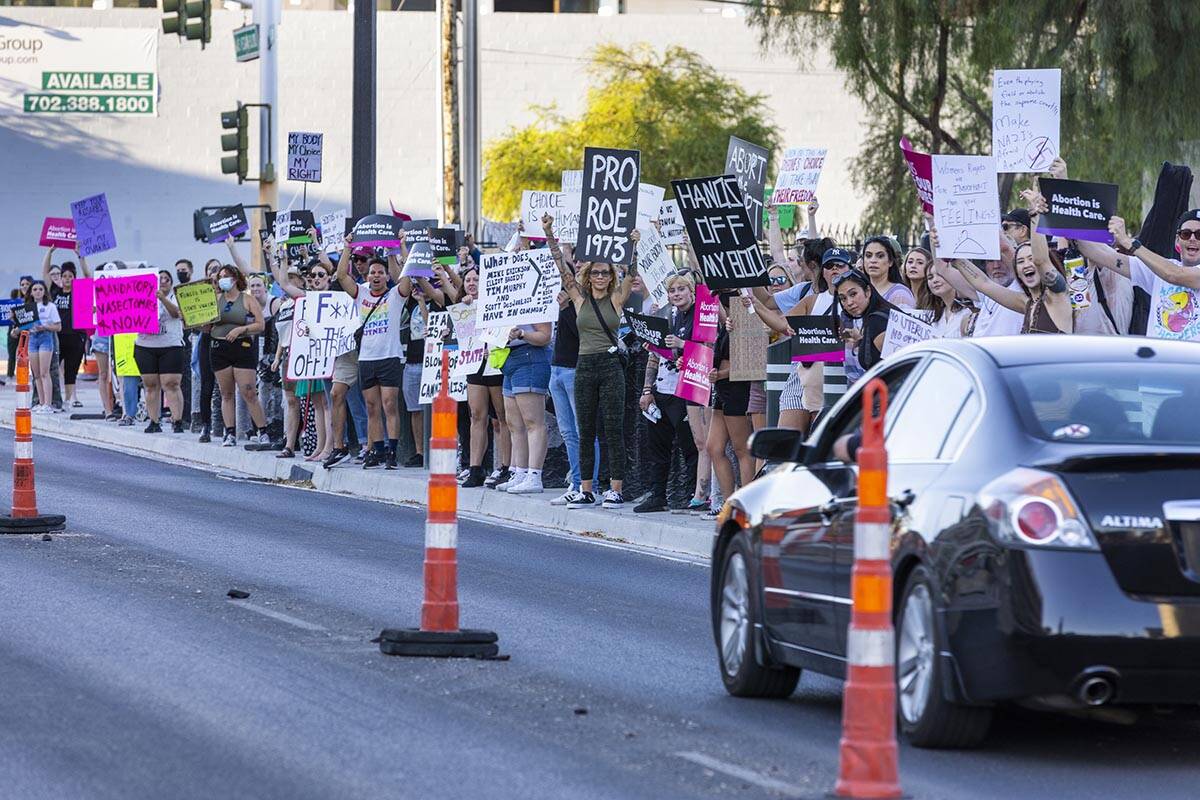 Protesters hold signs in response to Roe v. Wade being overturned today at the Lloyd D. George ...