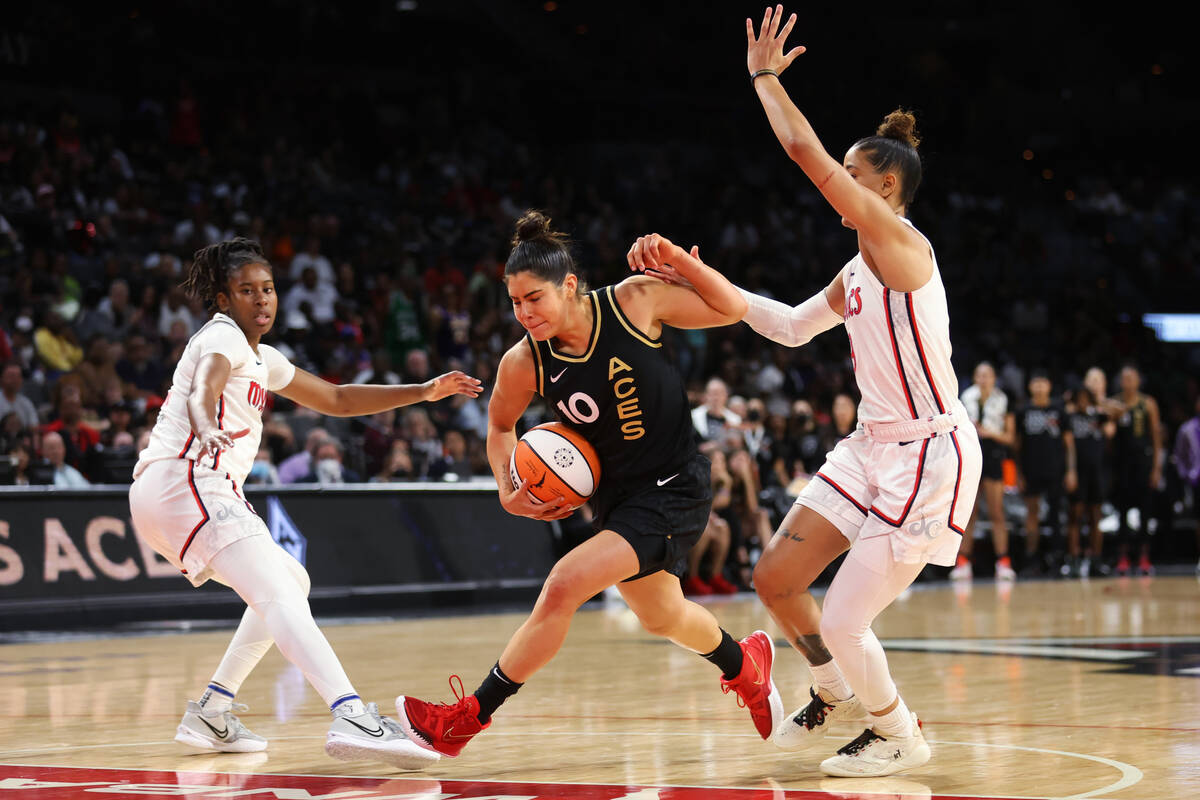 Las Vegas Aces guard Kelsey Plum (10) dribbles the ball to the hoop under pressure from Washing ...