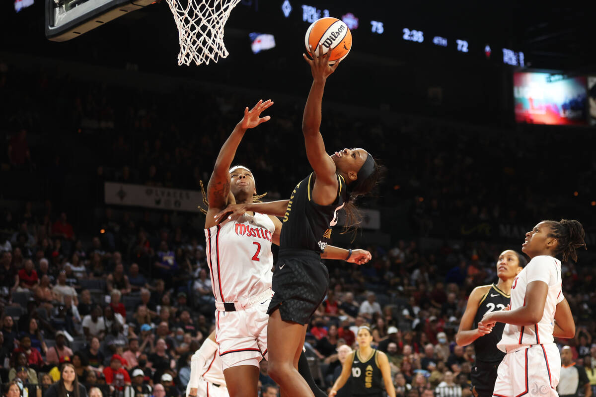 Las Vegas Aces guard Jackie Young (0) shoots the ball under pressure from Washington Mystics fo ...