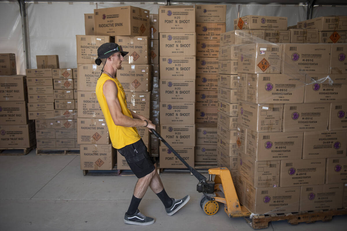 Andrew Thomas moves a pallet of fireworks at the Phantom Fireworks warehouse as workers prepare ...
