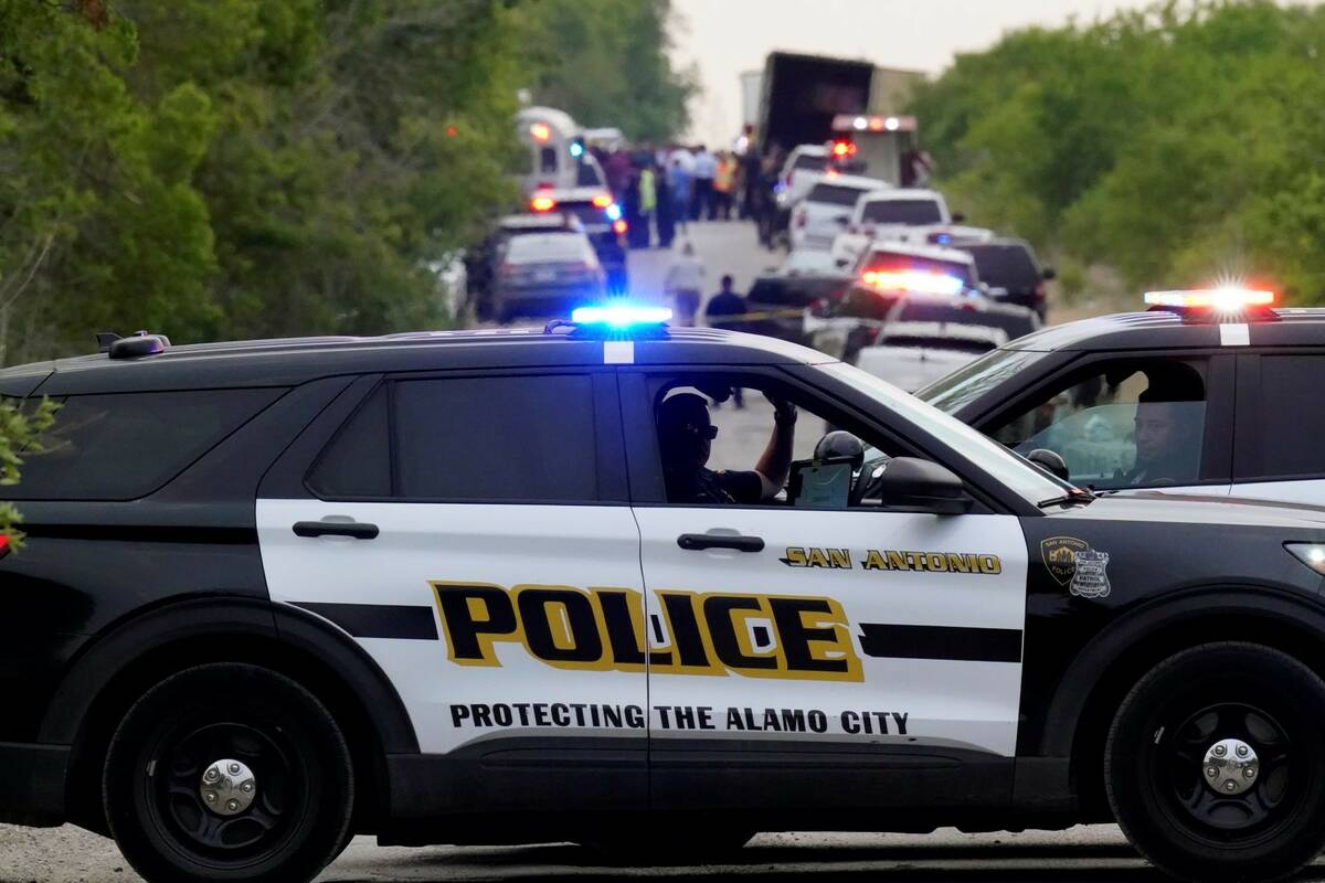 Police block the scene where a tractor trailer with multiple dead bodies was discovered, Monday ...