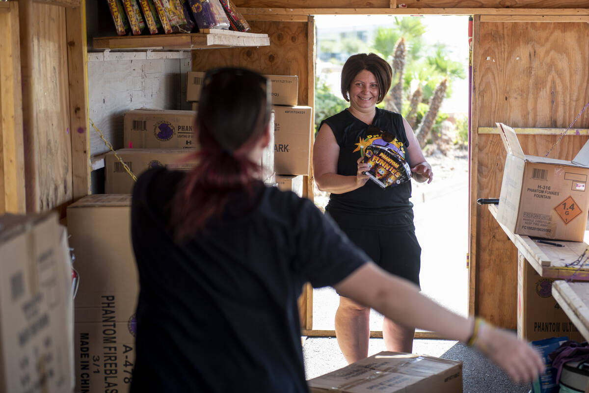 Hannah Dockery, left, goofs off with Shellie Moskos as they set up their Phantom Fireworks stan ...