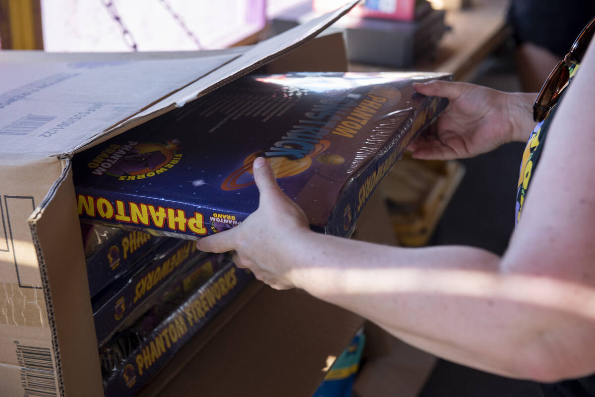 Shellie Moskos unpacks a box of fireworks as she helps set up her organization's Phantom Firewo ...