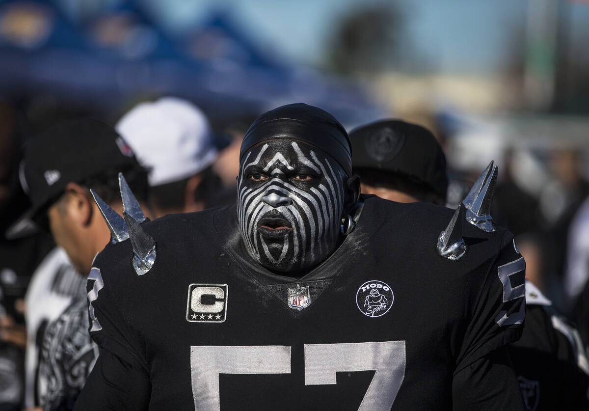 Raiders super fan Wayne Mabry, known as "Violator," walks through a tailgate outside the Oaklan ...