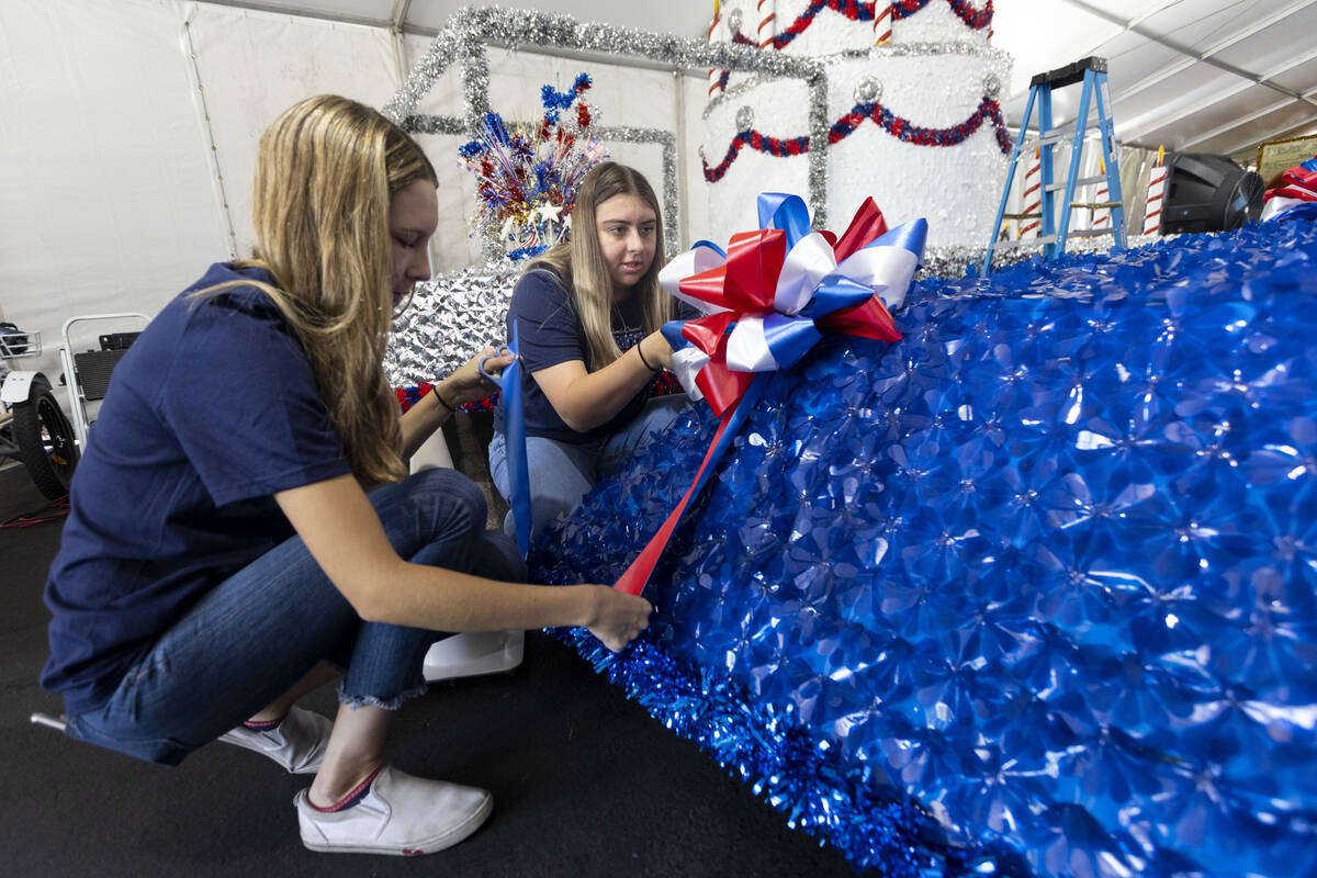 Volunteers Danielle Cox, left, and Jordyn Doyle put the finishing touches on a float during a S ...