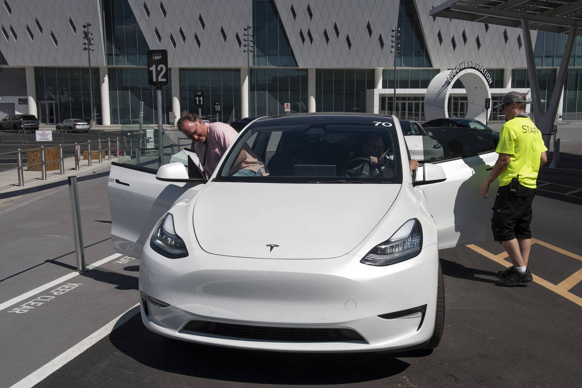 Andy Cameron, left, of Wyoming, gets into a Tesla at the Vegas Loop West Station heading to Res ...