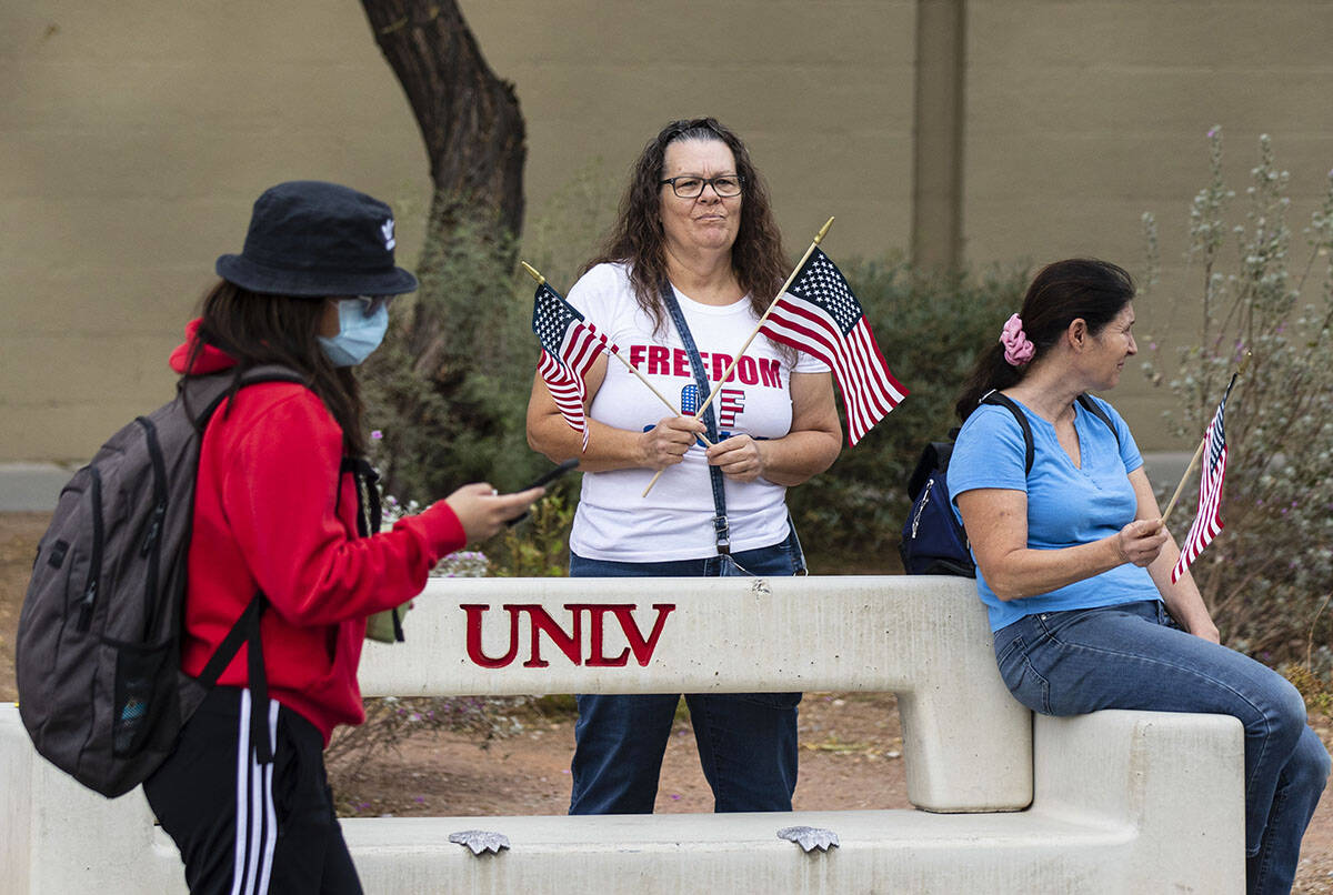 FILE - A UNLV student walks past protesters, including Susie K. of Las Vegas, right, as they pr ...