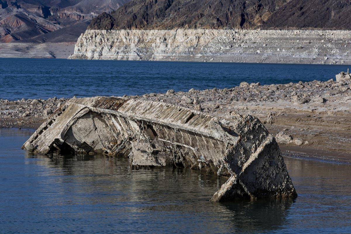 A WWII-era landing craft used to transport troops or tanks is being revealed on the shoreline n ...