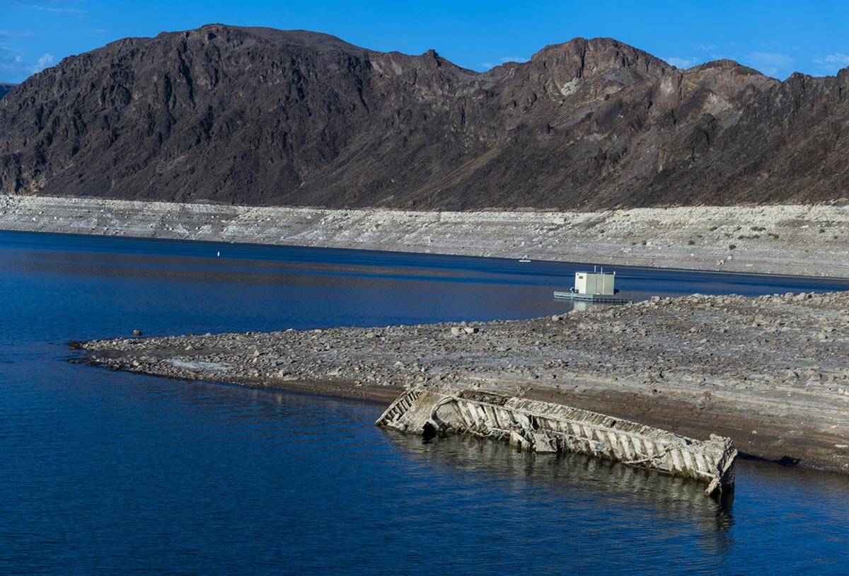 A WWII-era landing craft used to transport troops or tanks being revealed on the shoreline near ...