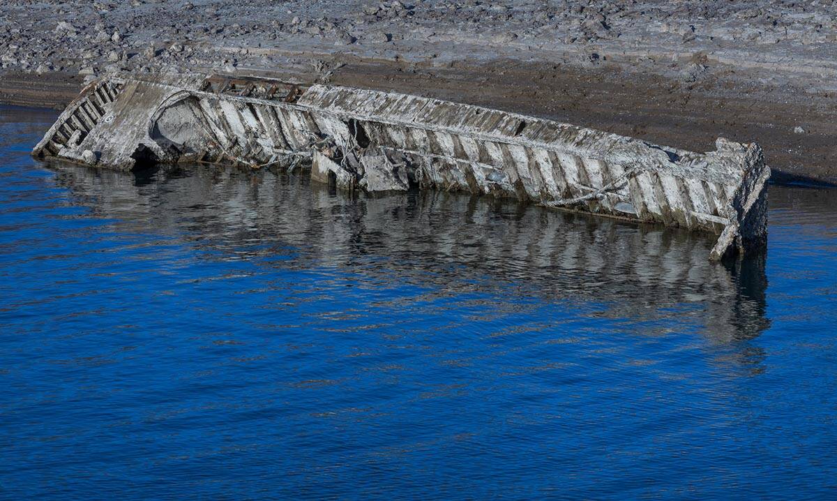 A WWII-era landing craft used to transport troops or tanks being revealed on the shoreline near ...