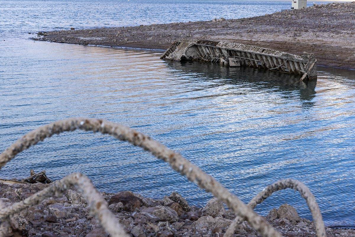 A WWII landing craft used to transport troops or tanks with old steel cable nearby being reveal ...