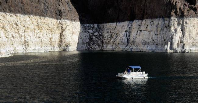 A pontoon boat cruises in the shadow of the bathtub ring on Lake Mead in the Lake Mead National ...