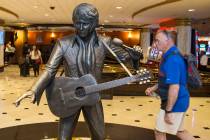 Guests pass by an Elvis Presley statue in the lobby of the Westgate in Las Vegas. (Benjamin Hag ...