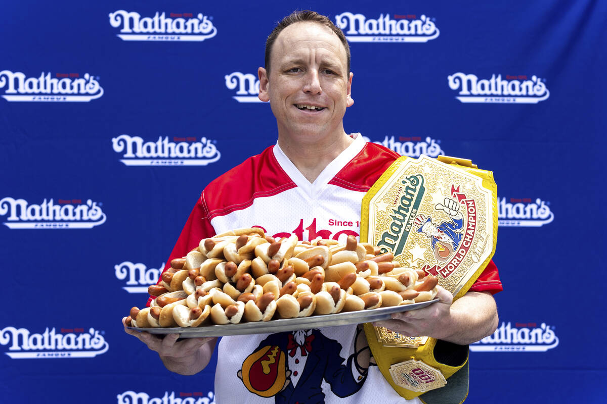 Competitive eater Joey Chestnut poses for photos with 76 hot dogs at a weigh-in before the Nath ...