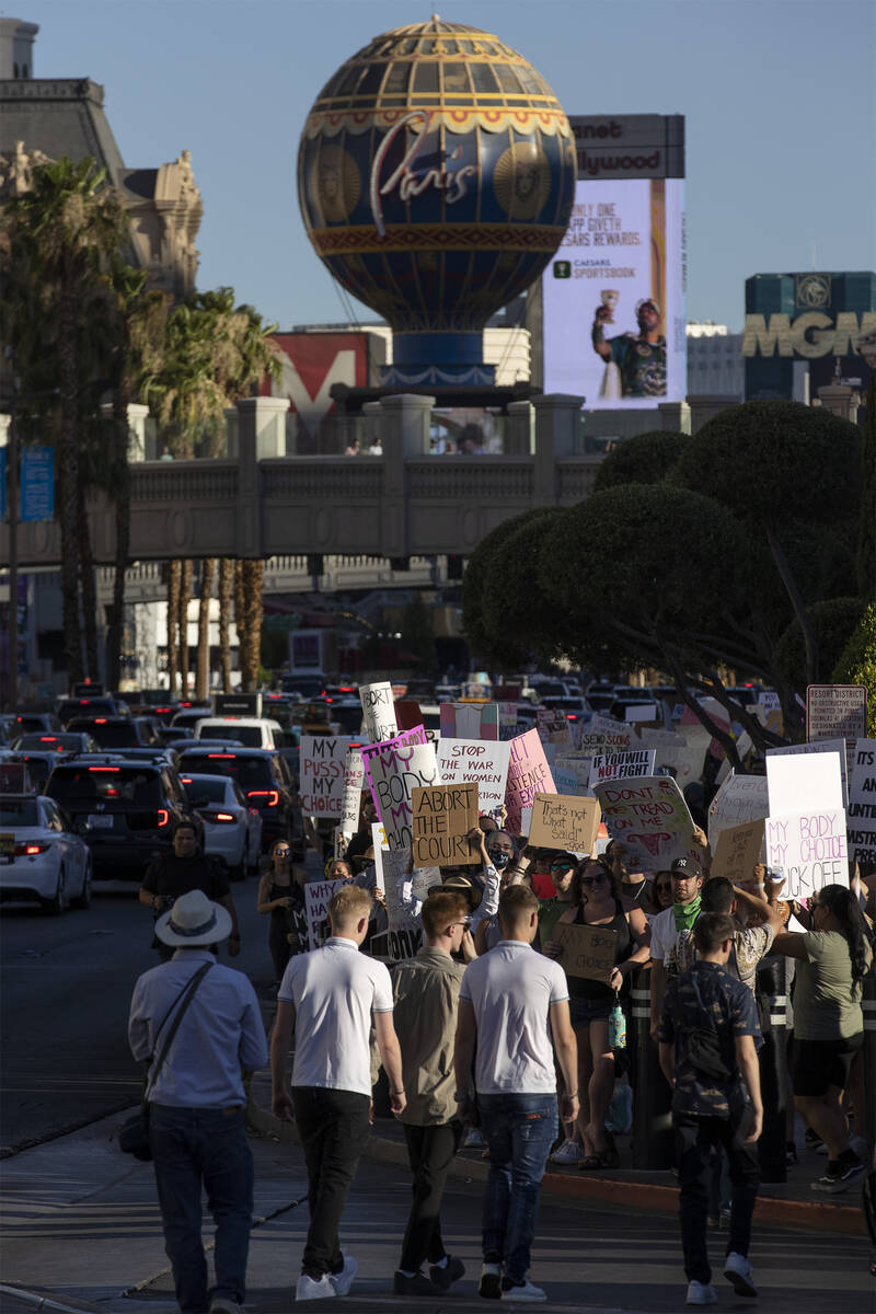 The Las Vegas Strip is seen in the background as protesters march on Las Vegas Boulevard during ...