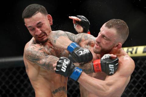 Alexander Volkanovski lands an elbow to Max Holloway in a mixed martial arts featherweight cham ...
