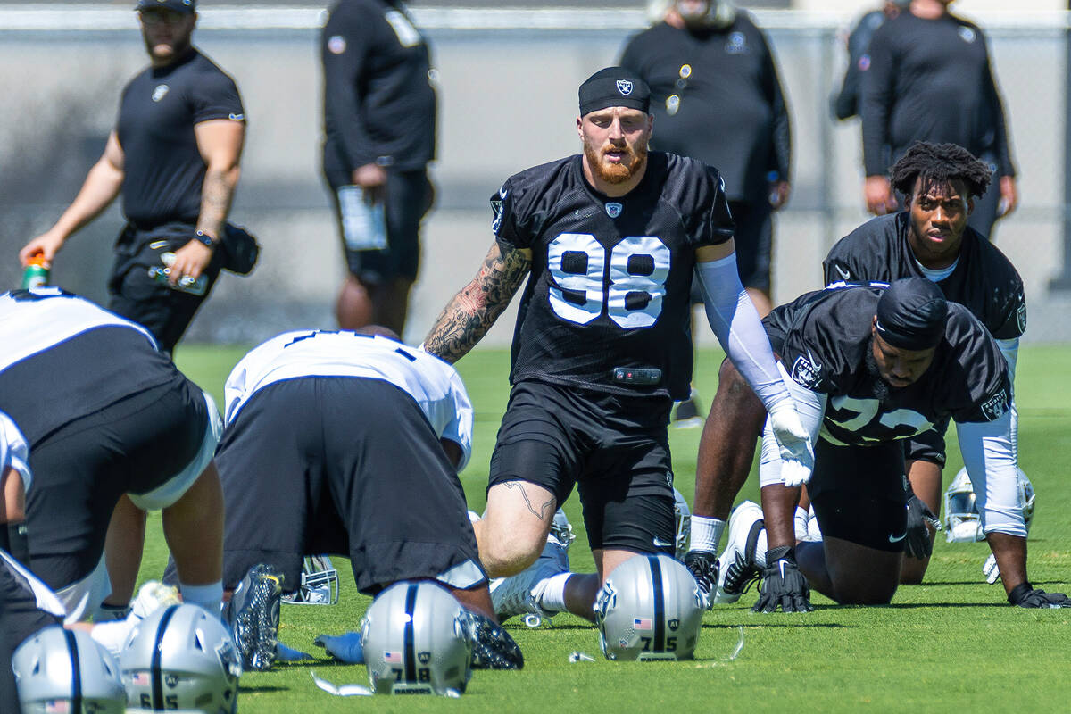 Raiders defensive end Maxx Crosby (98) talks beside defensive tackle Matthew Butler (73) and de ...