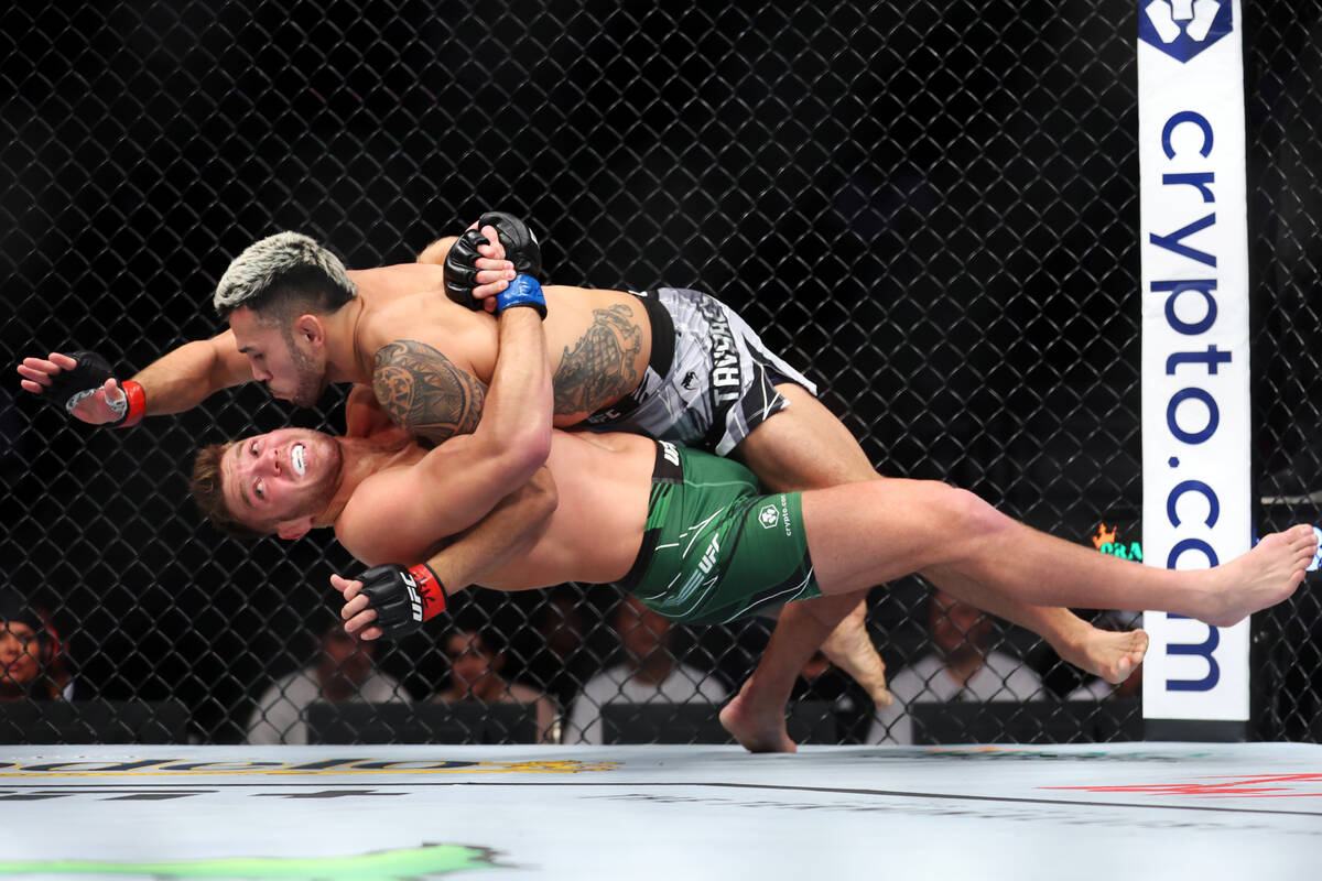 Dricus Du Plessis, bottom, takes down Brad Tavares during the first round in a middleweight bou ...