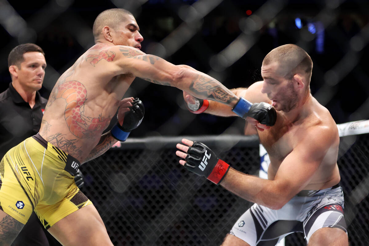 Alex Pereira, left, knocks out Sean Strickland during the first round in a middleweight fight a ...