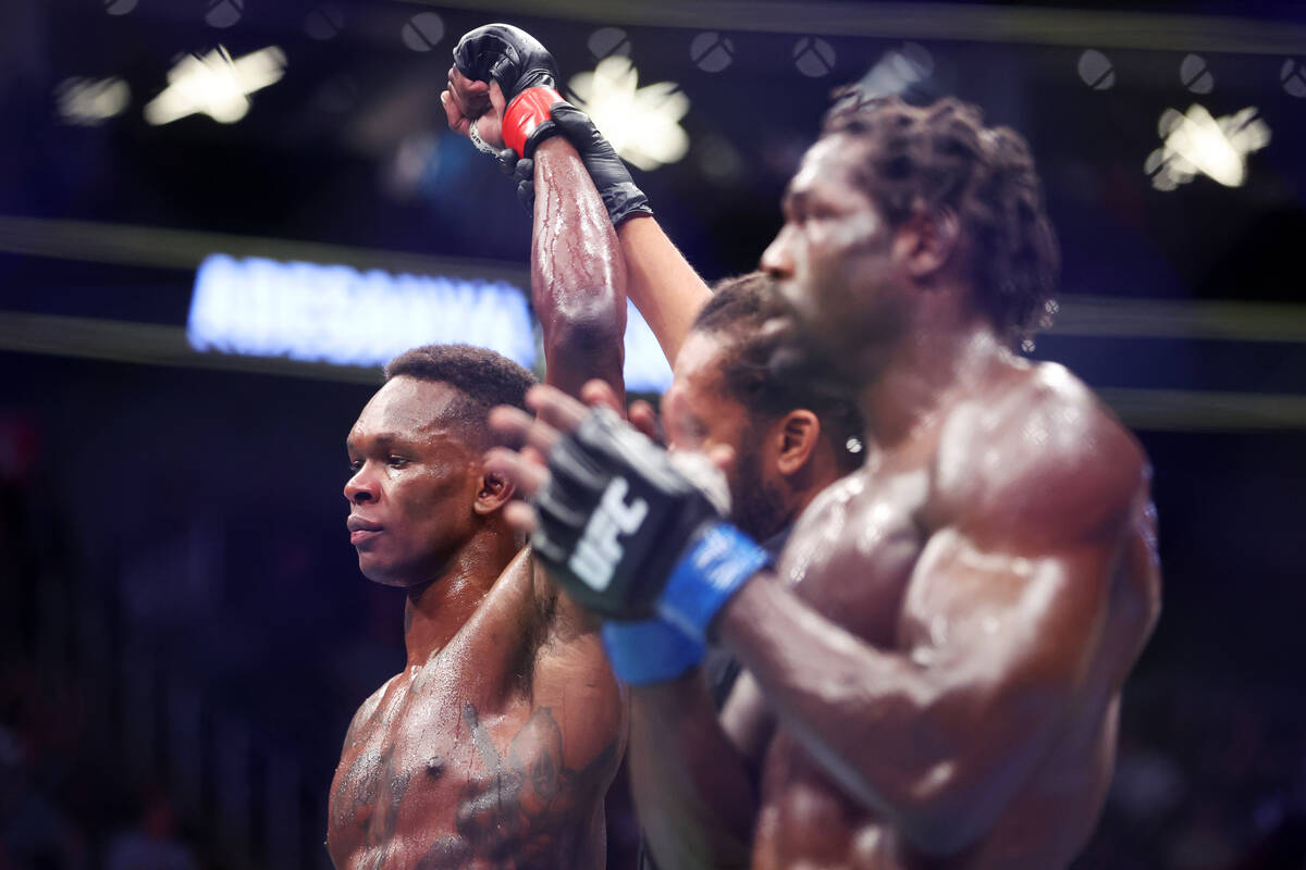 Israel Adesanya, left, is announced the winner by unanimous decision against Jared Cannonier in ...