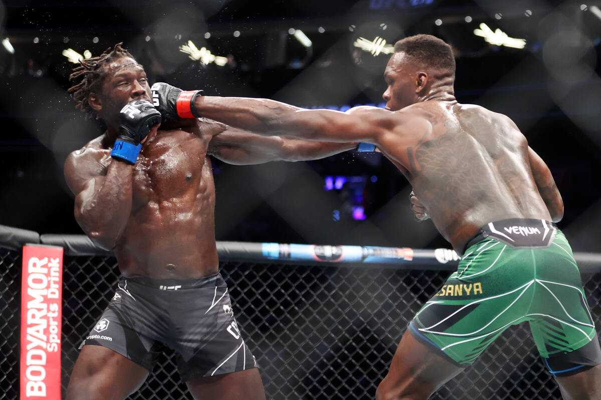 Israel Adesanya, right, throws punch against Jared Cannonier during the third round of a middle ...