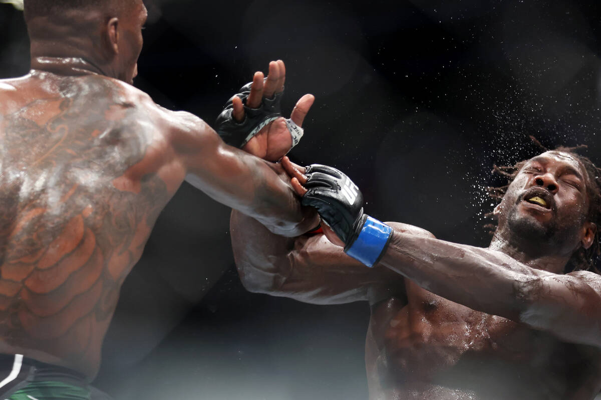 Israel Adesanya, left, connects a punch against Jared Cannonier during the second round of a mi ...
