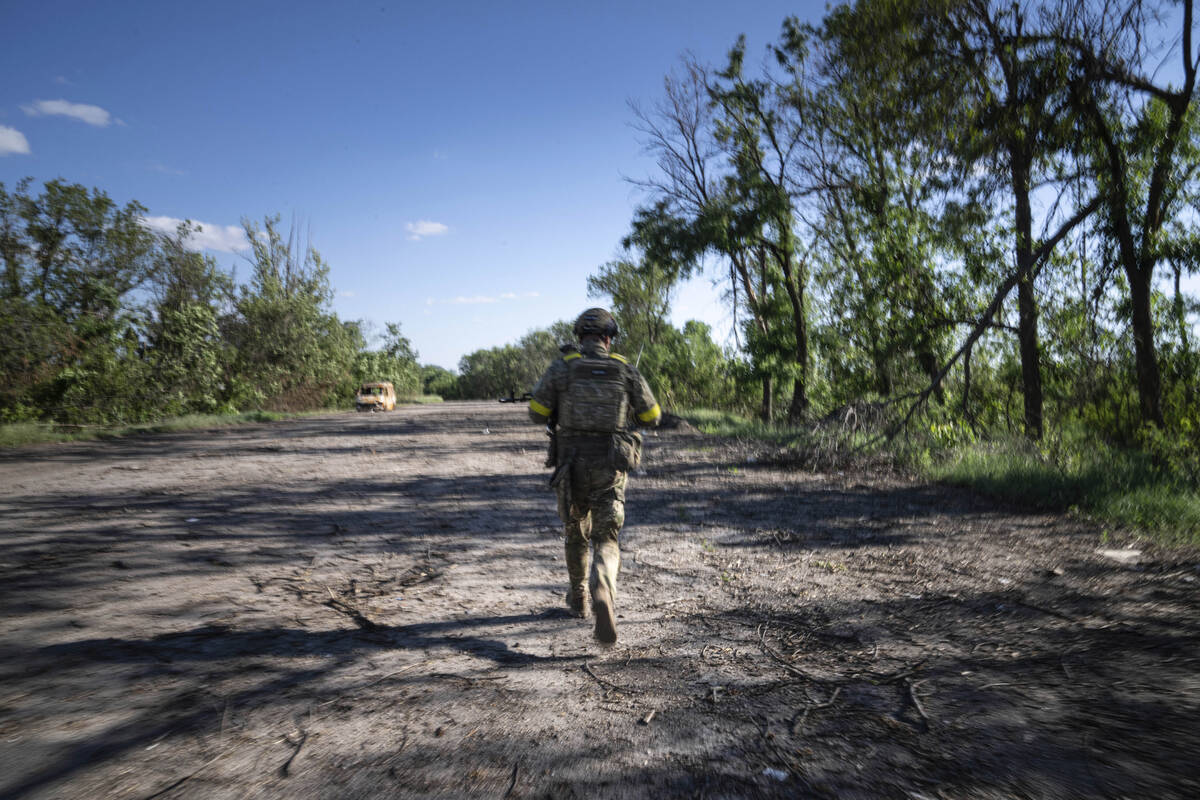 A Ukrainian serviceman changes his position at the frontline near Kharkiv, Ukraine, on Saturday ...