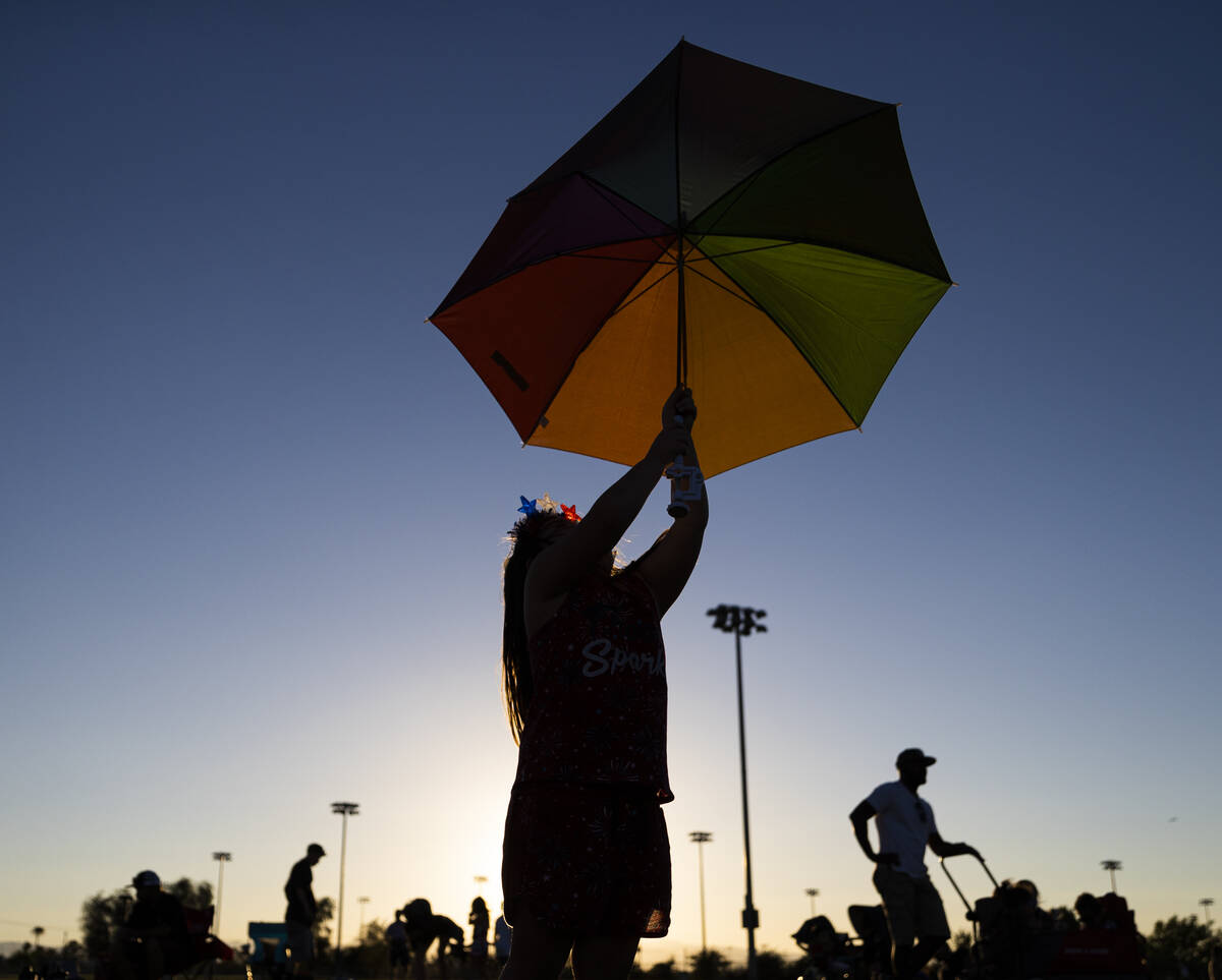 Aria Trujillo, 4, plays with an umbrella before the start of a Fourth of July celebration at He ...