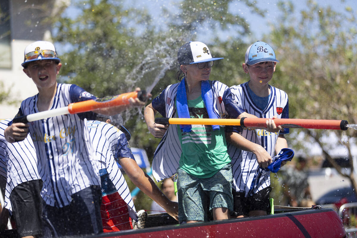 Children spray water on the crowd from a moving truck in the water zone following the Boulder C ...