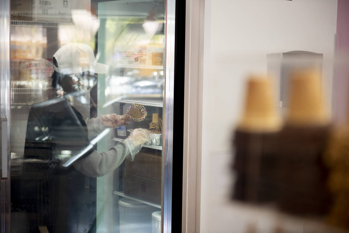 Employee Axel Vega stores specialty waffle cones in the cooler at Cream Me Ice Creamery on Main ...