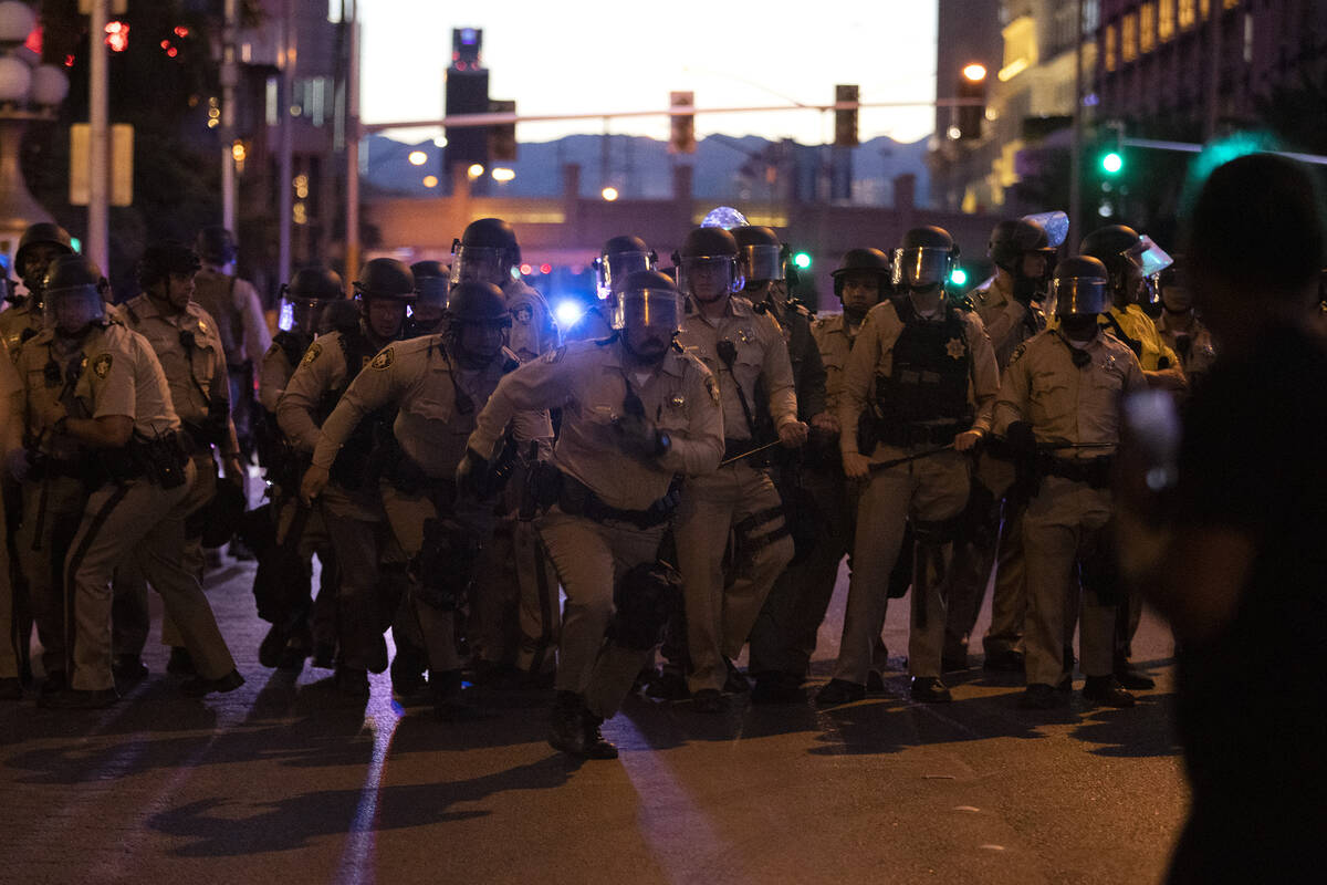 Las Vegas police officers run toward the crowd of protesters who took to the Las Vegas Strip in ...