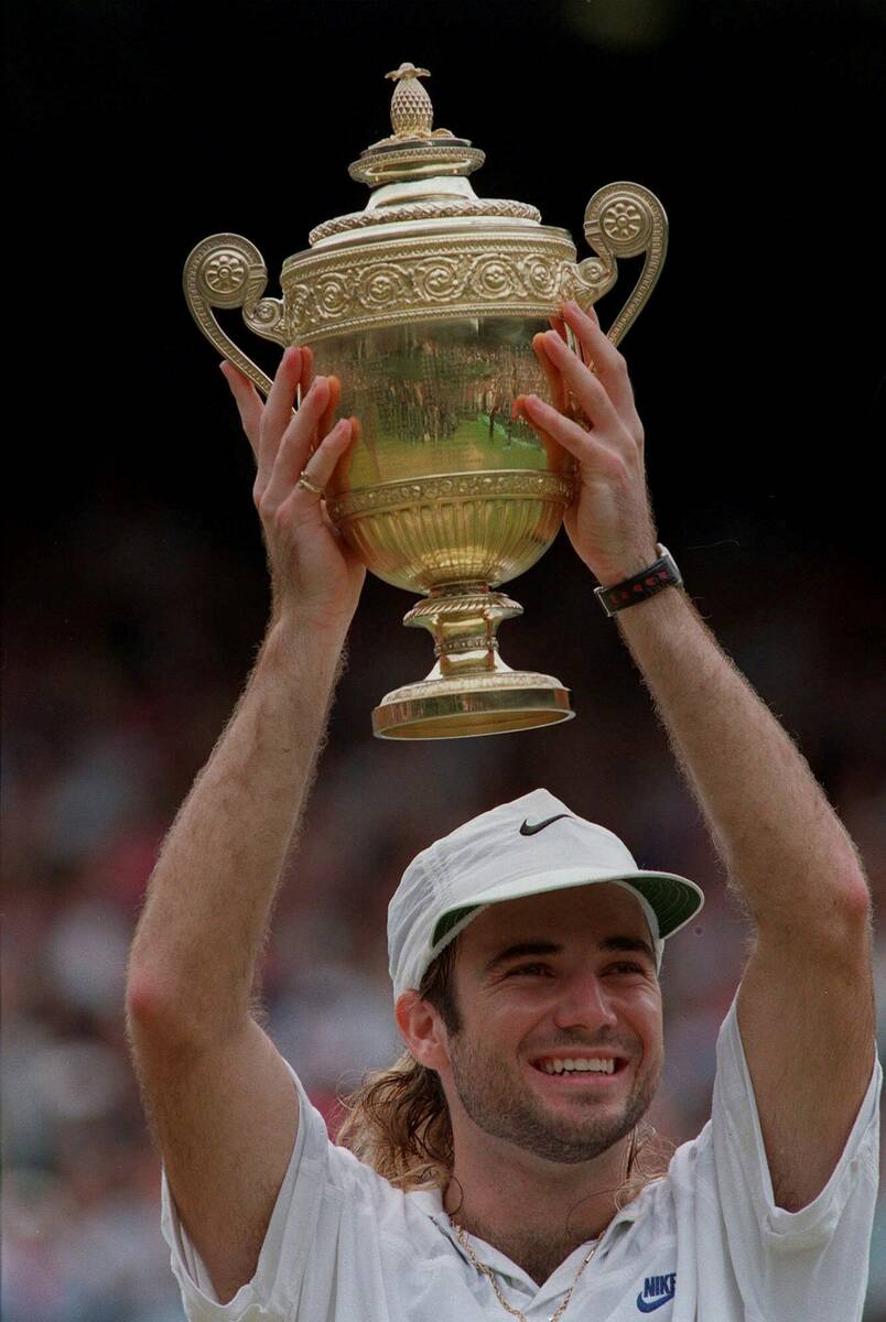 Andre Agassi holds up his championship trophy after defeating Goran Ivanisevic to win the men's ...