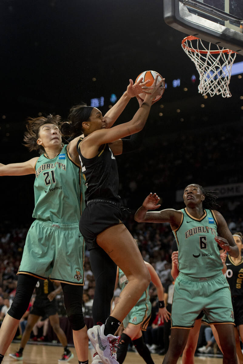Las Vegas Aces forward A'ja Wilson (22) gets fouled by New York Liberty's Han Xu (21) during th ...