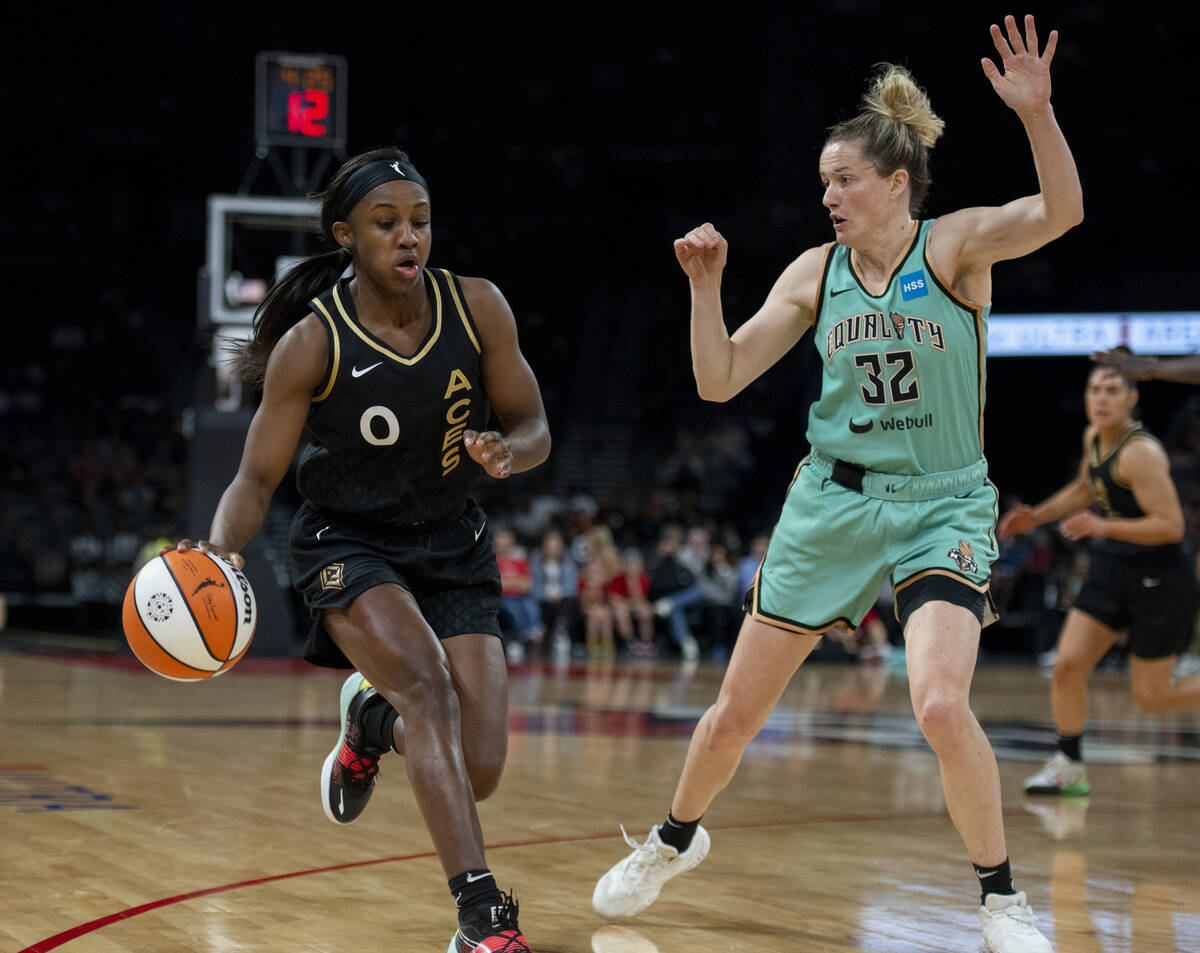 Las Vegas Aces guard Jackie Young (0) drives past New York Liberty's Sami Whitcomb (32) during ...