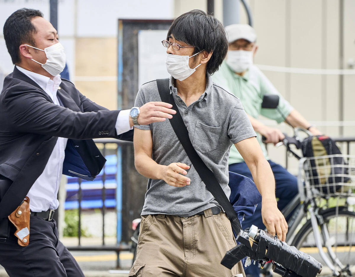 CORRECTS SECOND SENTENCE - Tetsuya Yamagami, center, holding a weapon, is detained near the sit ...