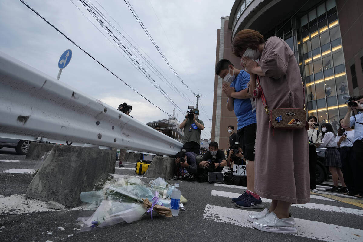 People pray after putting a bouquet of flowers at a makeshift memorial at the scene where the f ...