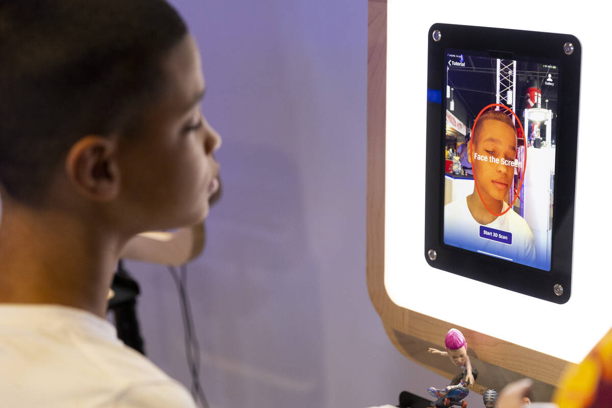 Audric Newsome, 15, creates a custom basketball figure at the Action Face booth during the NBA ...